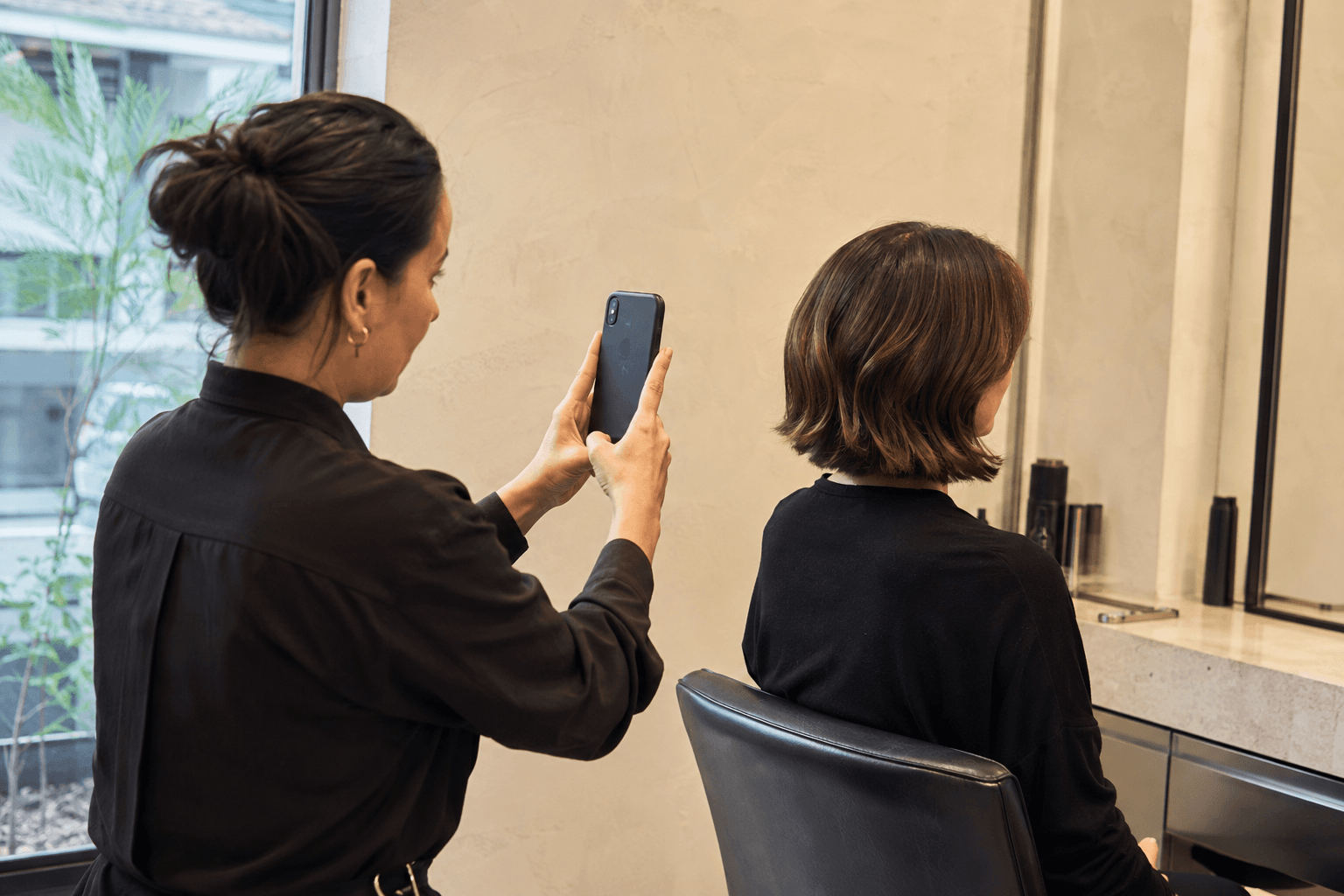 Cabeleireira fotografando o resultado do seu trabalho no salão